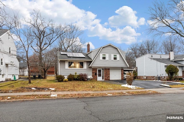 view of front of home with solar panels, cooling unit, and a garage