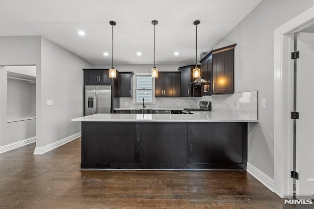 kitchen with tasteful backsplash, kitchen peninsula, hanging light fixtures, and stainless steel appliances