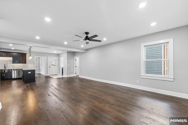 unfurnished living room featuring ceiling fan and dark hardwood / wood-style floors