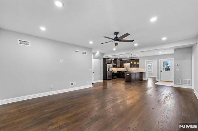 unfurnished living room featuring ceiling fan, sink, and dark hardwood / wood-style floors