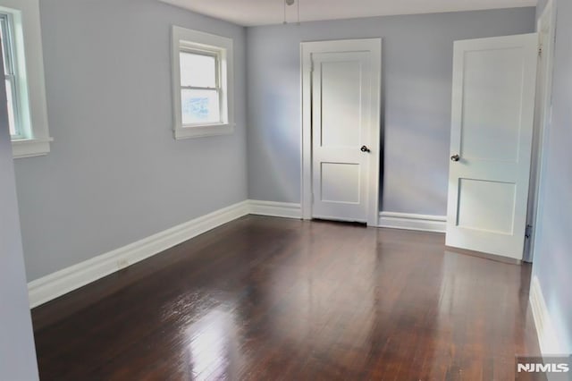 unfurnished room featuring dark wood-type flooring