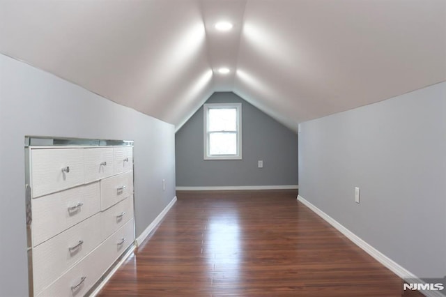 additional living space with dark hardwood / wood-style floors and lofted ceiling