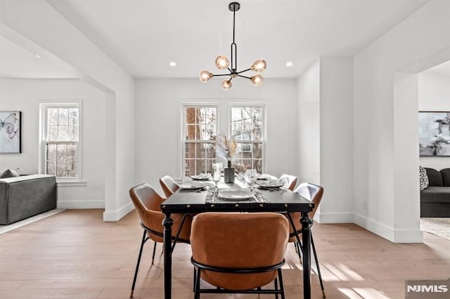 dining room with light hardwood / wood-style flooring and a notable chandelier