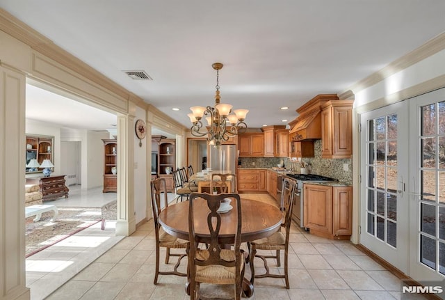 tiled dining space featuring a notable chandelier, french doors, and ornamental molding