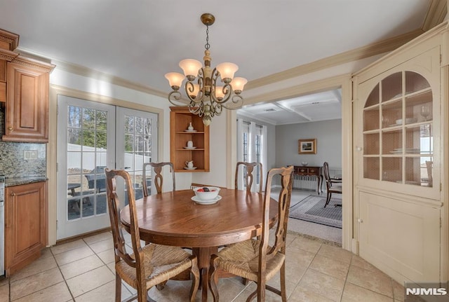 tiled dining room featuring french doors, crown molding, and a chandelier