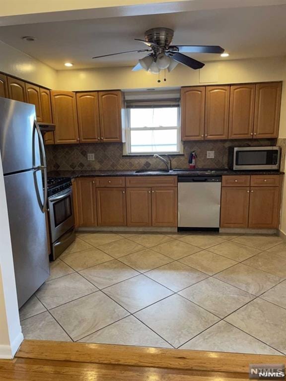 kitchen featuring stainless steel appliances, ventilation hood, ceiling fan, sink, and light tile patterned floors