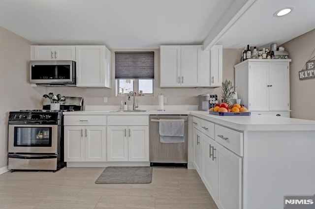 kitchen featuring stainless steel appliances, white cabinetry, and sink