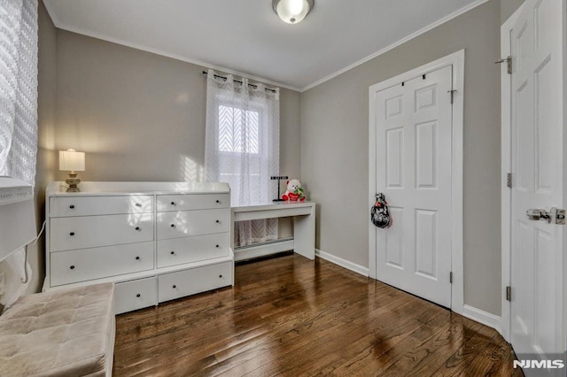 bedroom with crown molding, dark wood-type flooring, and a baseboard heating unit