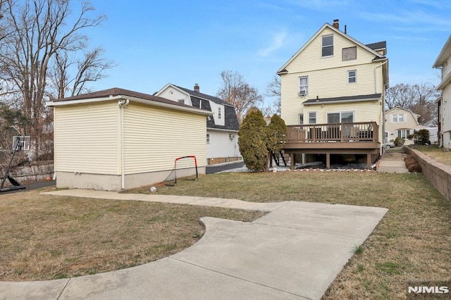 rear view of property featuring a yard and a wooden deck