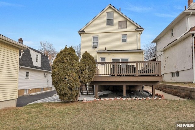 rear view of property with a deck and a lawn