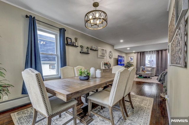 dining room with crown molding, a healthy amount of sunlight, dark wood-type flooring, and a chandelier