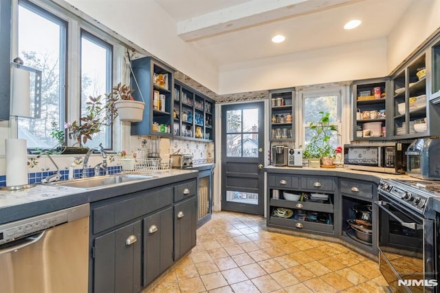 kitchen with a wealth of natural light, sink, beamed ceiling, and appliances with stainless steel finishes