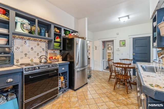 kitchen featuring stainless steel fridge, blue cabinetry, and black / electric stove