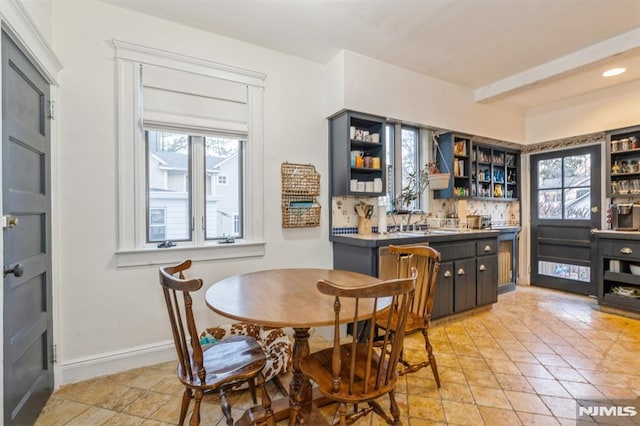 dining area featuring beamed ceiling and sink