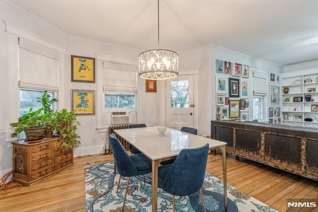 dining area featuring a chandelier, cooling unit, light hardwood / wood-style floors, and ornamental molding