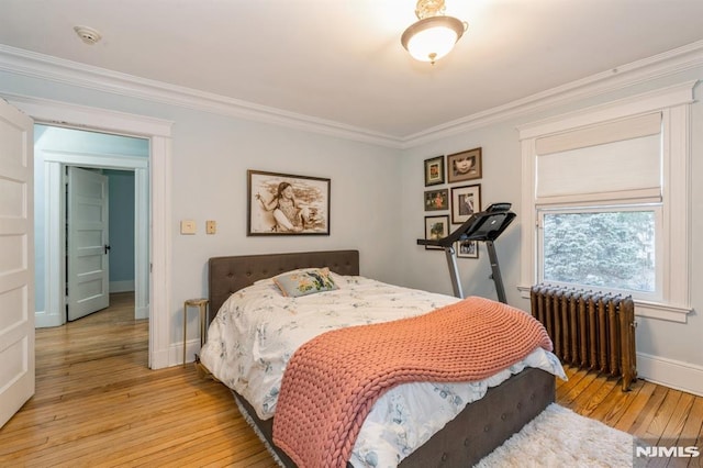 bedroom with radiator, light hardwood / wood-style flooring, and ornamental molding