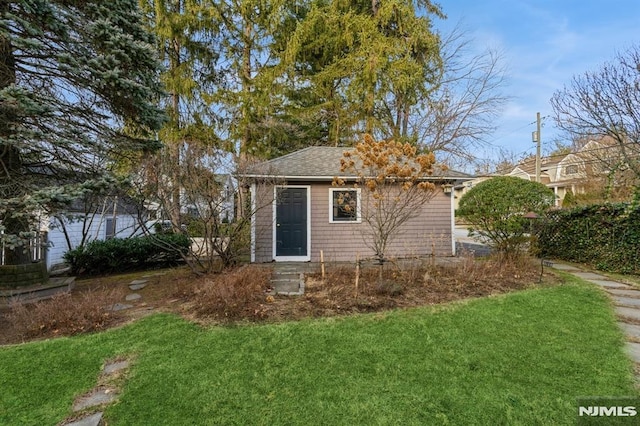 rear view of property featuring a lawn