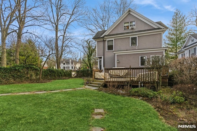 back of house with a lawn and a deck