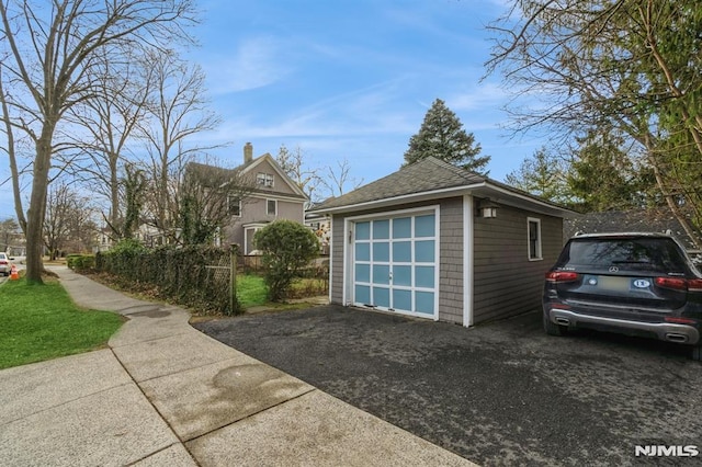 view of side of home with a garage and an outdoor structure