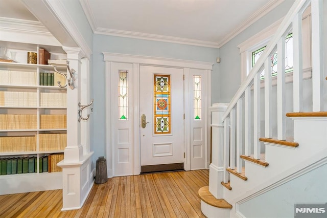 foyer entrance featuring ornamental molding and light hardwood / wood-style flooring