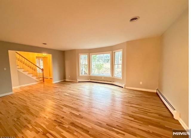 unfurnished room with wood-type flooring and baseboard heating