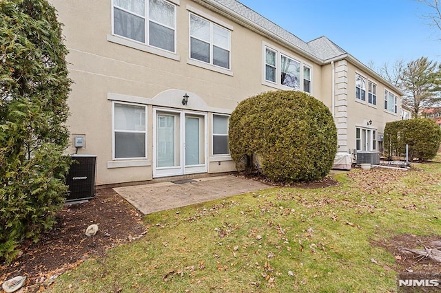 back of property with a yard, cooling unit, and a patio area