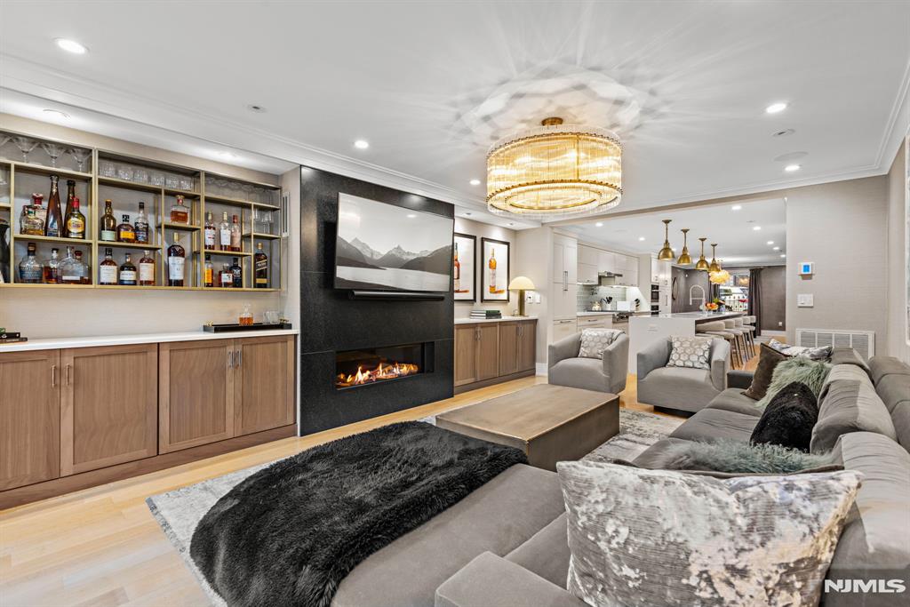 living room featuring light hardwood / wood-style floors, a notable chandelier, and ornamental molding