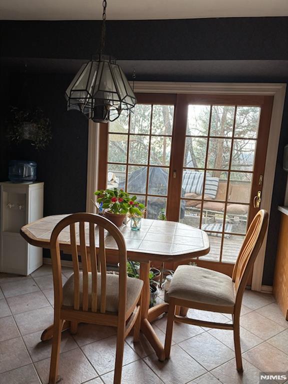 tiled dining space featuring a chandelier