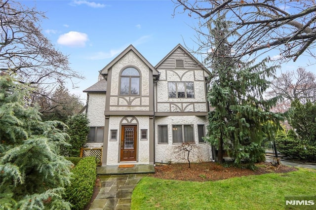 tudor house featuring a front yard