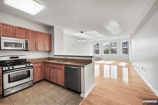 kitchen with pendant lighting, sink, kitchen peninsula, and stainless steel appliances