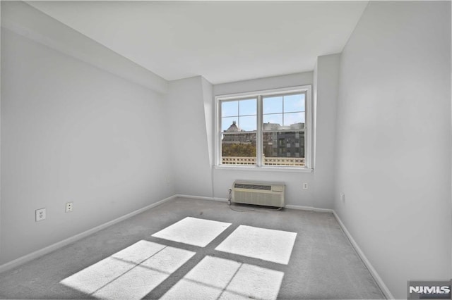 carpeted empty room featuring a wall unit AC