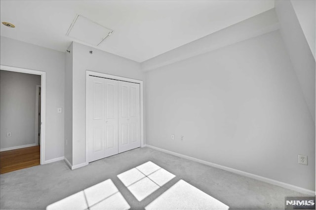 unfurnished bedroom featuring light carpet and a closet