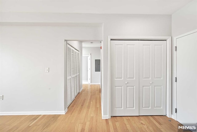 hall featuring electric panel and light hardwood / wood-style flooring