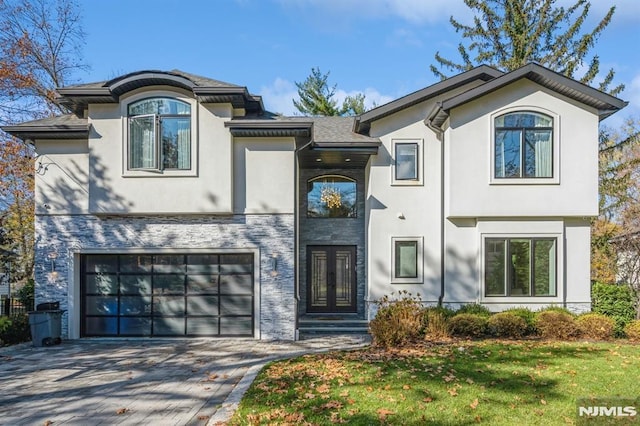 view of front of property featuring french doors, a front lawn, and a garage