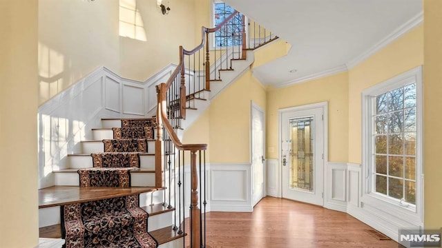 stairs with hardwood / wood-style flooring and crown molding