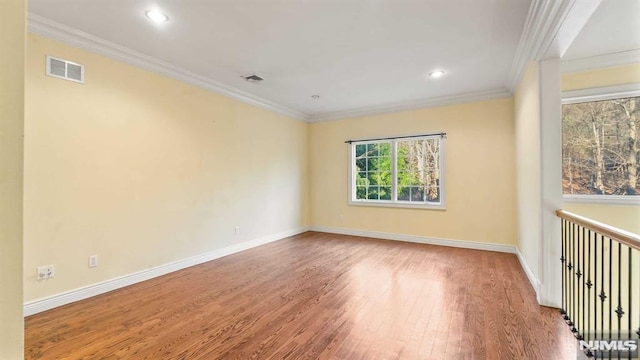 spare room featuring hardwood / wood-style flooring and ornamental molding