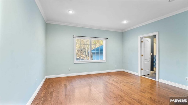 spare room with hardwood / wood-style flooring and crown molding