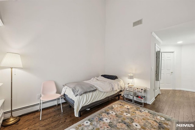 bedroom featuring a baseboard heating unit, crown molding, and dark hardwood / wood-style floors