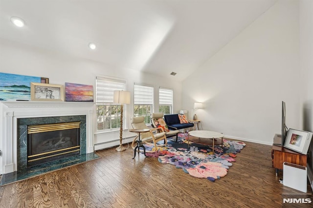 sitting room featuring a fireplace, baseboard heating, vaulted ceiling, and dark hardwood / wood-style floors