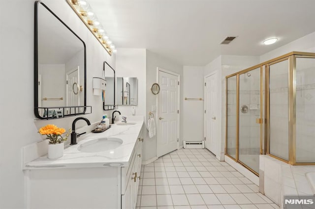 bathroom with a baseboard heating unit, a shower with door, tile patterned floors, and vanity