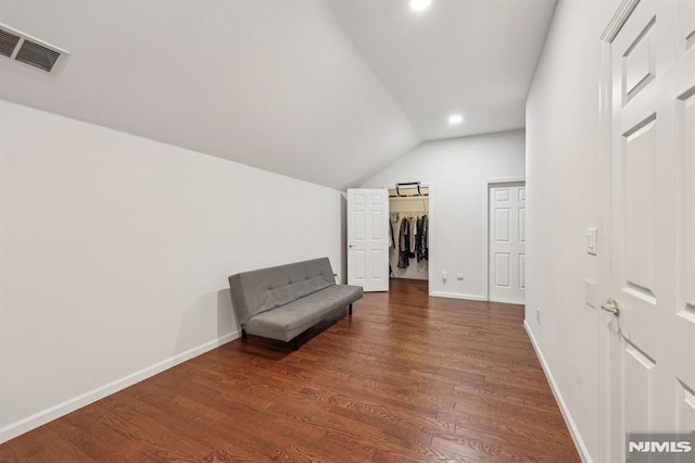 sitting room featuring vaulted ceiling and dark wood-type flooring