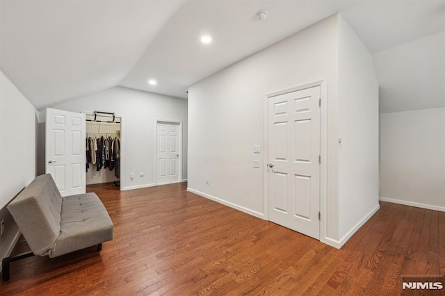 interior space featuring hardwood / wood-style flooring and vaulted ceiling