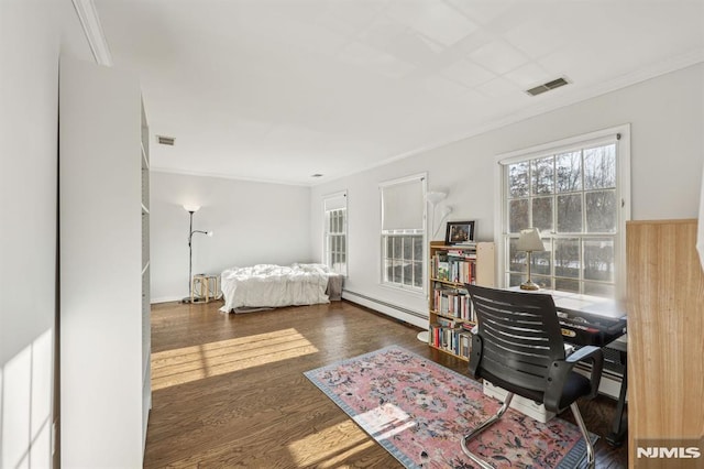 bedroom featuring dark hardwood / wood-style flooring, baseboard heating, and ornamental molding