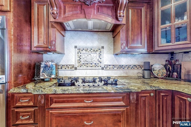 kitchen featuring tasteful backsplash, gas cooktop, stone countertops, and custom exhaust hood