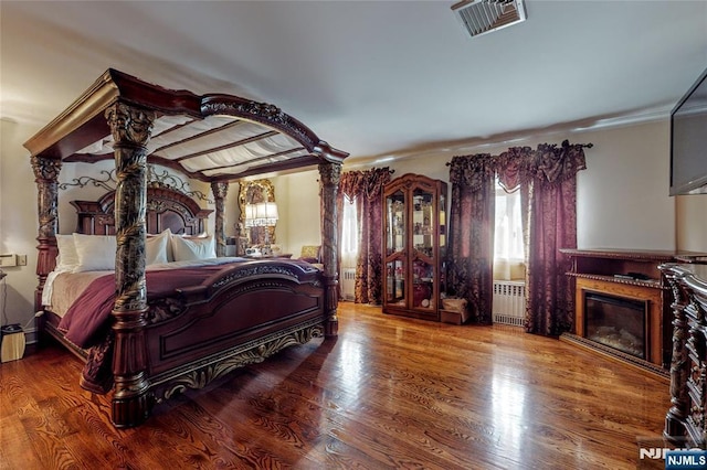 bedroom featuring hardwood / wood-style flooring and radiator heating unit