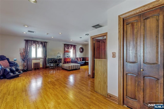 bedroom featuring radiator heating unit and light wood-type flooring