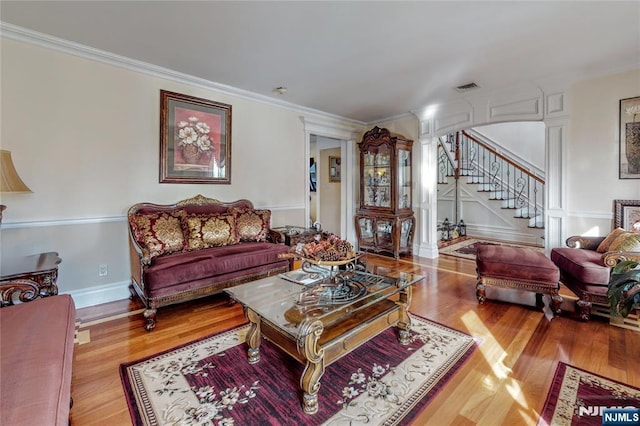 living room with crown molding and light hardwood / wood-style floors