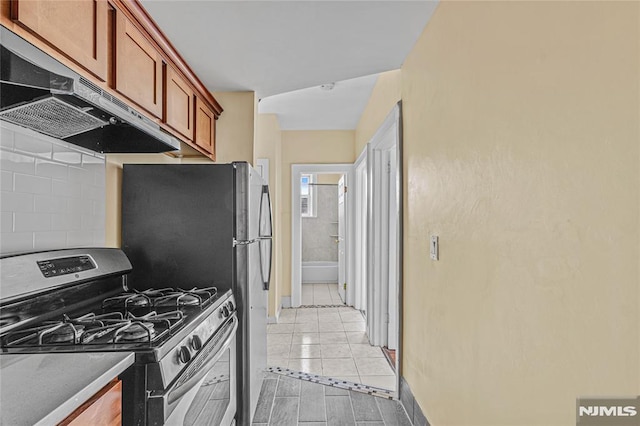 kitchen with extractor fan and stainless steel range with gas cooktop