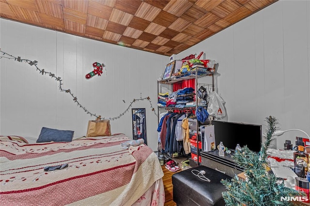 bedroom with wood-type flooring, wooden walls, and wooden ceiling