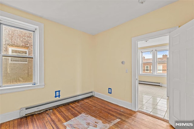 spare room featuring light hardwood / wood-style floors and baseboard heating